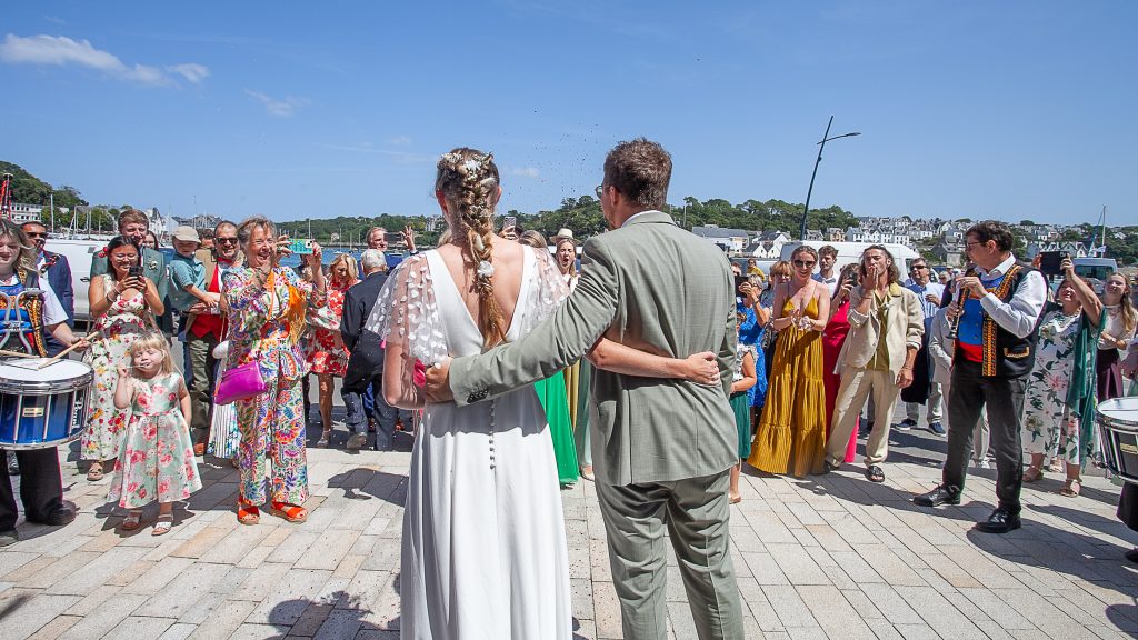 photo de mariage avec els mariées de dos face à la foule