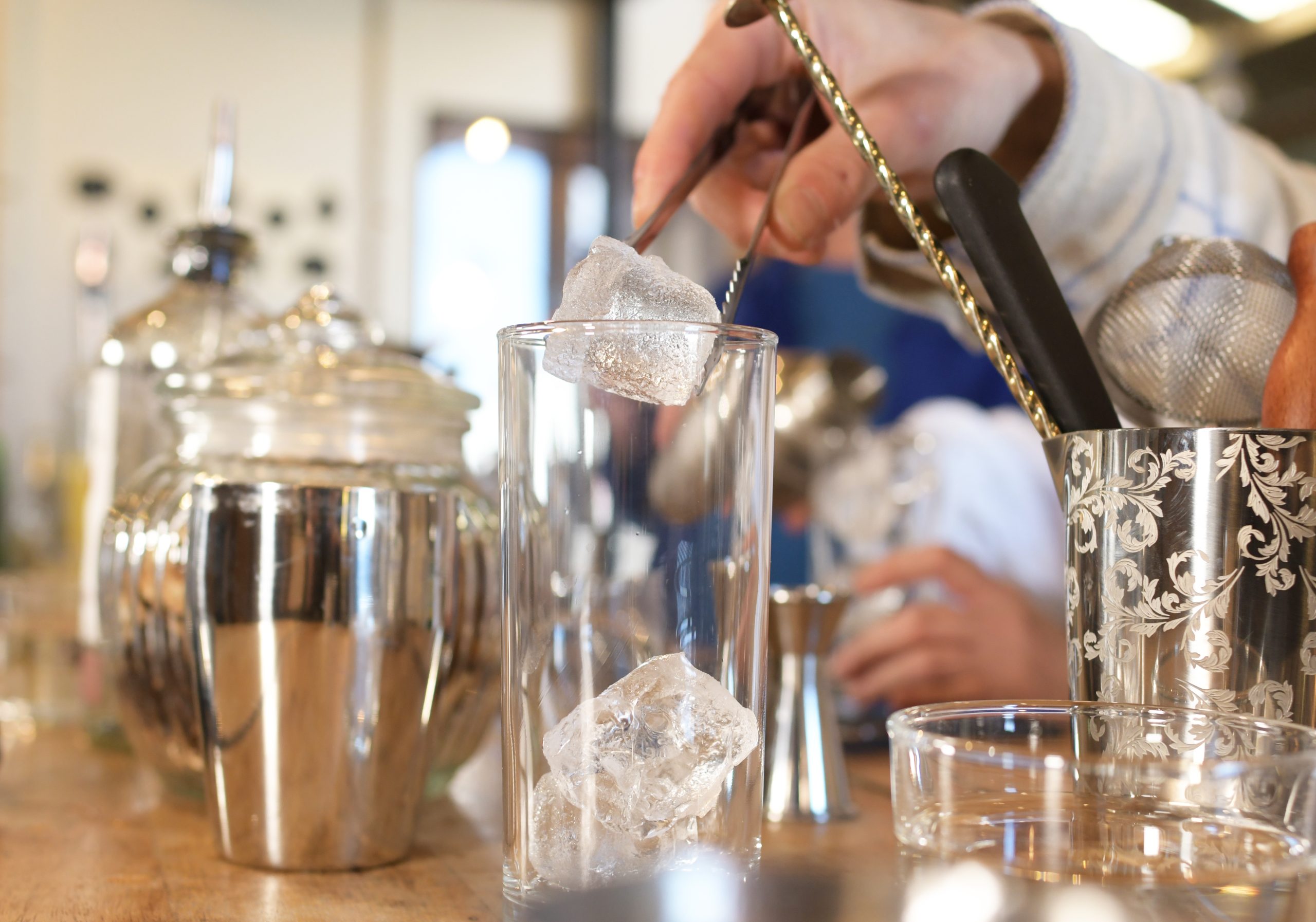 préparation d'un cocktail en mettant des glaçons dans un verre à cocktail de sabulle cocktail bretagne