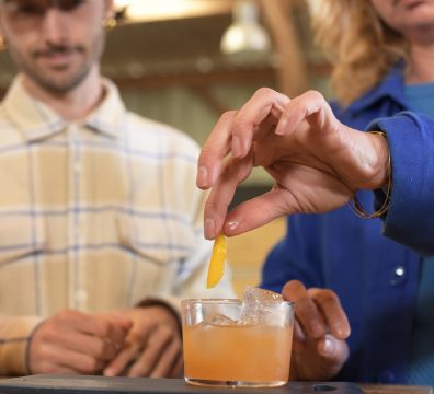 participant déposant un zeste d'orange dans un cocktail artisanal lors d'un atelier mixologie Sabulle Cocktail Bretagne