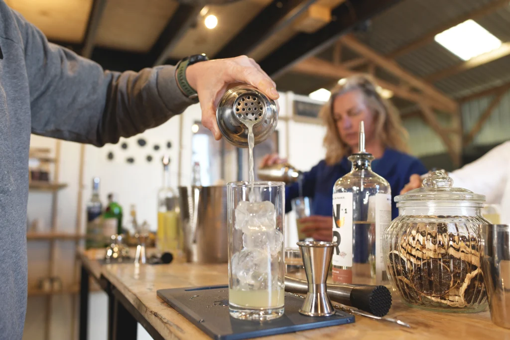 participant atelier cocktail Sabulle Cocktail filtration shaker dans verre glacé lors d'une initiation mixologie en Bretagne