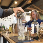 participant atelier cocktail Sabulle Cocktail filtration shaker dans verre glacé lors d'une initiation mixologie en Bretagne